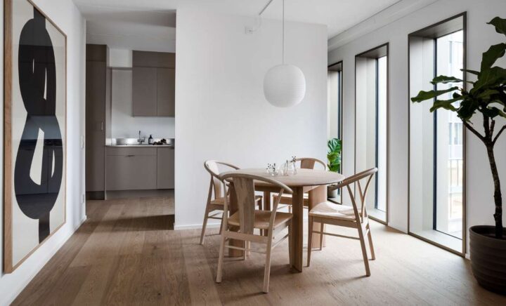 Interior view with windows to the right and kitchen in the background